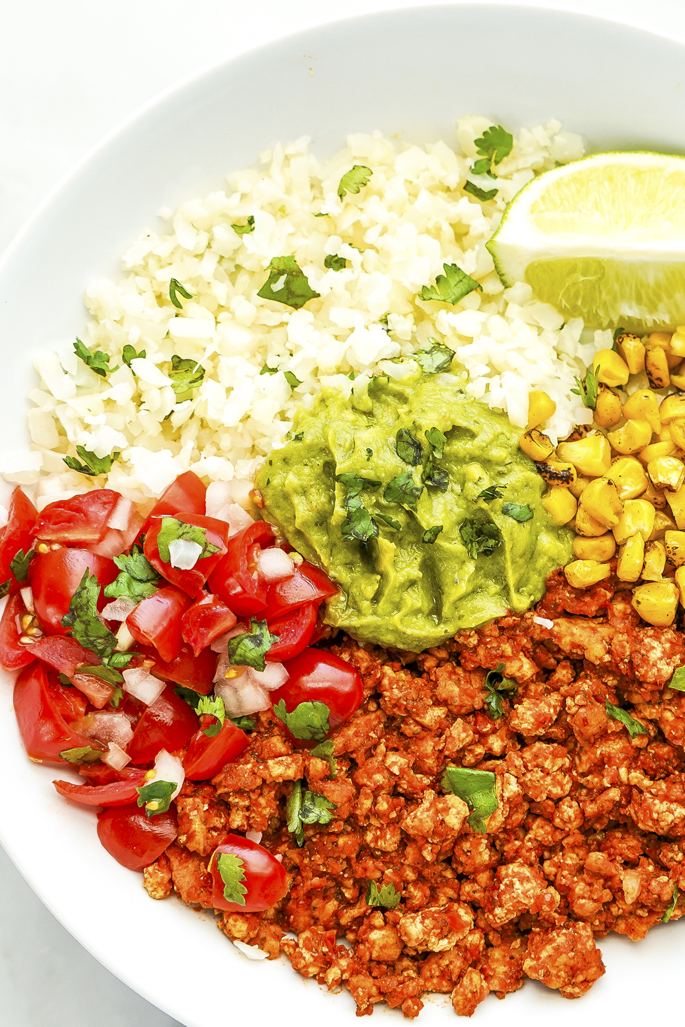 This easy burrito bowl recipe has lots of filling, topping, and protein choices, with vegetarian options, for cauliflower rice burrito bowls. SumofYum.com Cauliflower Rice Burrito Bowl with Chipotle sofritas and corn salsa